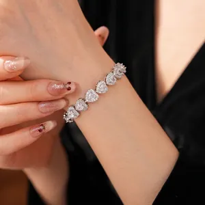 Sparkling zircon heart link bracelet in silver finish on woman's wrist