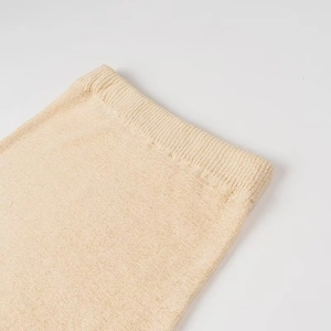 Dettaglio ravvicinato della trama a costine in maglia beige chiaro del completo wasteland