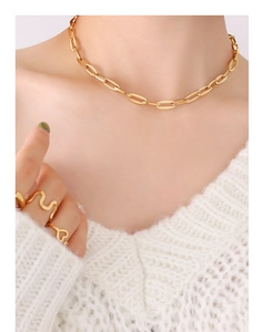 Close-up of a 18K gold plated chain necklace and minimalist rings on a female model