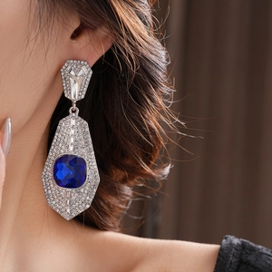 Macro shot of oversized geometric square earring with blue crystal and rhinestones