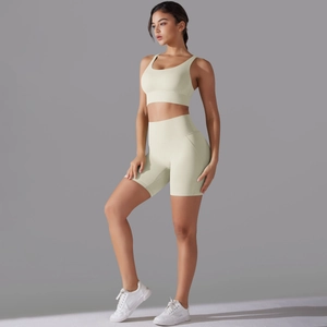 Dettaglio di un set yoga verde chiaro con reggiseno sportivo e pantaloncini a vita alta aderenti