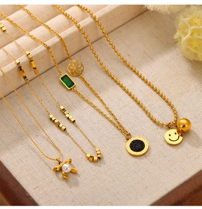 Detailed display of five gold necklaces with pearl rabbit and emerald pendants