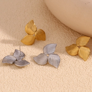 Detail of brushed 18K gold and silver petal stud earrings with creative boomerang design