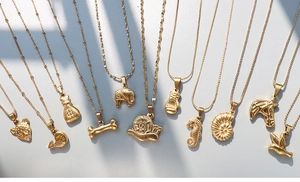 Detailed view of various gold-plated stainless steel pendants with animal and symbolic shapes