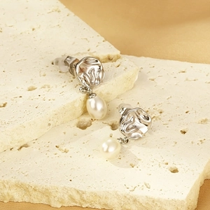 Détail de boucles d'oreilles en métal martelé argenté avec perles en forme de goutte