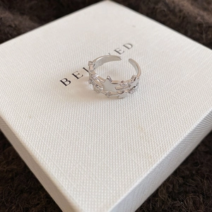 Detail of silver double-layer open ring featuring polished stars and clear zircon accents