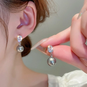 Détail de boucles d'oreilles en argent avec cristaux brillants et perles gris foncé chic