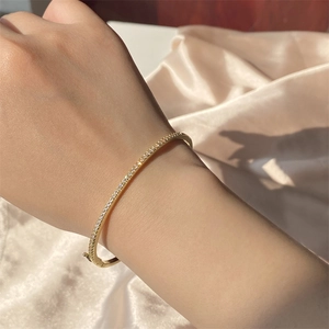 Detail of a gold-plated bracelet with micro-pave cubic zirconia worn on the wrist