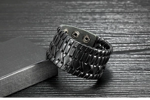 Detail of black braided leather wristband with adjustable metal snap fasteners