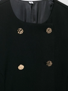 Dettaglio del blazer nero doppiopetto con bottoni dorati a rilievo e tessuto in twill