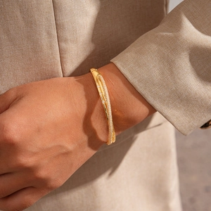 Detailed view of 18k gold plated crisscross bangle with micro-pave white crystals