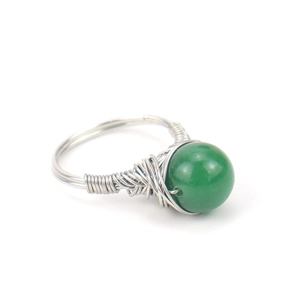 Detail of silver wire-wrapped ring featuring a green natural crystal bead