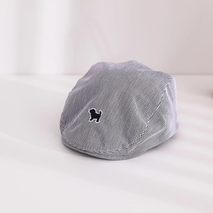 Détail de la casquette bébé à rayures avec broderie chien et texture en coton doux