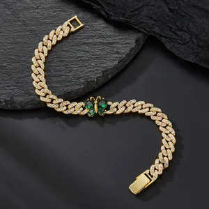 Close-up of Cuban link chain with emerald green butterfly and pavé set cubic zirconia