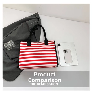 Detail of red and white striped canvas tote bag with black strap and metal snap closure