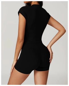 Detail view of the black slim-fit short sleeve top and high waist compression yoga shorts