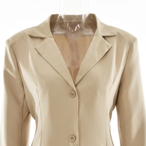 Detail view of a beige notched lapel blazer with button closure on a mannequin stand
