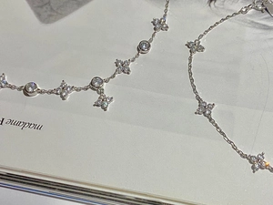 Detail of 925 silver 18K gold clover bracelet with zircons on a magazine page