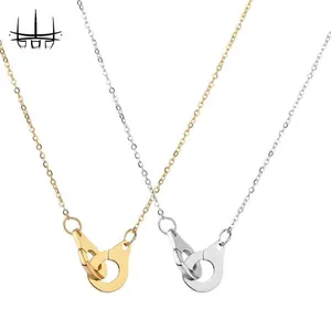 Detailed macro view of interlocking handcuffs pendant necklaces in gold and silver finish