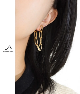 Detailed view of bohemian gold chain earrings in stainless steel on a model
