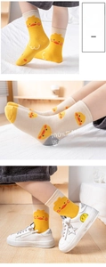 Detail of candy-colored mid-tube cotton socks with cute cartoon duck patterns and ribbed cuffs