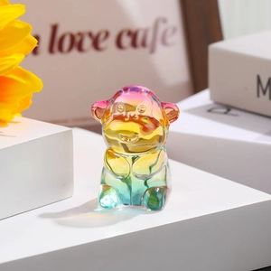 Rainbow gradient glass monkey figurine on a white platform with a cozy home decor background