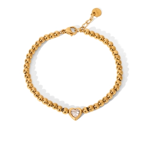Close-up of golden stainless steel beaded bracelet with clear heart zircon pendant