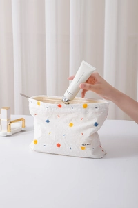 Detail showing the cotton canvas texture and colorful dot embroidery of this cosmetic bag