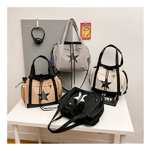 Detail of colorful nylon tote bags with drawstring and pentagram logo for travel