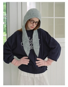 Winter outfit detail showing grey knitted hooded scarf and pink knit gloves on a model