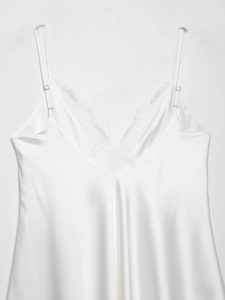 Détail de la robe en satin blanc avec bordure en dentelle cil et fines bretelles