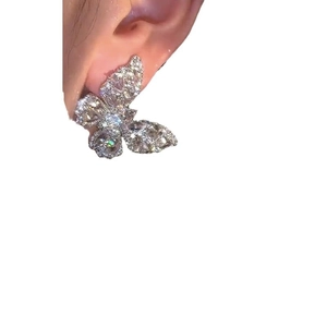 Sparkling silver butterfly earrings with zircon stones shown on a model's ear