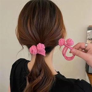 Detail of pink Chinese knot hair tie on a ponytail with high-elastic braided texture
