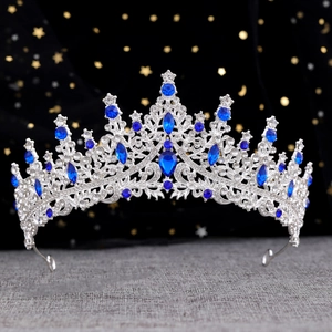 Macro detail of silver crown with blue pear-shaped crystals and sparkling white rhinestones