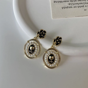 Detailed view of camellia stud with vintage gold tulip relief and pearl-encrusted oval pendant