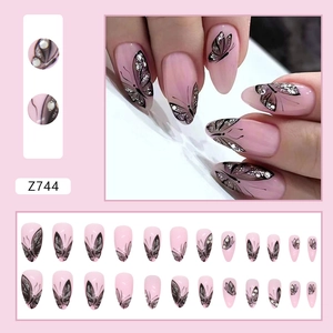 Macro view of pink almond press-on nails with black glitter butterfly motifs and 24 pieces