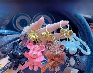 Detailed close-up of resin bears with woven texture and gold keyrings in four colors