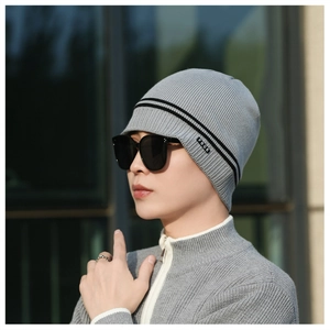 Close-up of light grey winter beanie with black stripes and FBQE label for men