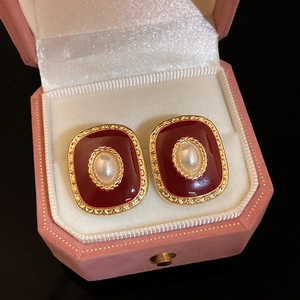 Vue détaillée de boucles d'oreilles vintage en émail rouge plaqué or avec incrustation perle