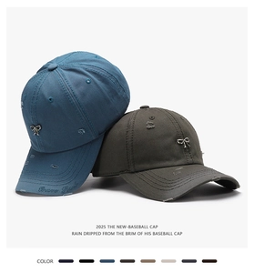 Close-up of distressed cotton baseball cap with metal bow buckle and brim embroidery