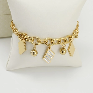 Bracciale in oro inox con ciondoli geometrici e zircone bianco su cuscino portagioielli