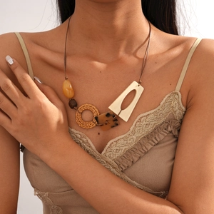 Dettaglio di collana boho con perline in legno, ciondoli in resina e charm in rattan