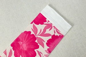 Détail de l'imprimé floral rose sur la robe montrant une couture double aiguille précise
