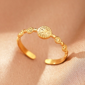 Detailed macro view of bohemian gold open ring with hammered round disc and sunburst texture