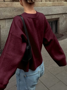 Rückansicht eines weinroten Oversize-Strickpullovers mit Laternenärmeln und Rippbündchen