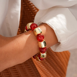 Close-up of red glitter beads and gold geometric metallic spacers on a beaded bracelet