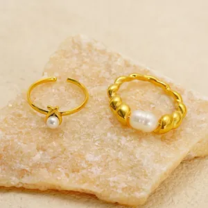 Elegant gold-tone stainless steel rings with natural freshwater pearls on natural stone