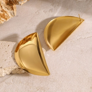 Macro shot of gold crescent hoop earrings with a polished concave metal finish on stone