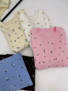 Flat lay of colorful crewneck sweaters with floral patterns in various pastel shades