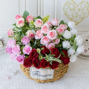 Artificial pink red and white roses in a woven basket for home and wedding decor